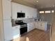 Modern kitchen with white cabinets, granite counters, and stainless steel appliances at 22110 N Lobo Ln, Sun City West, AZ 85375