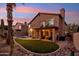 A backyard with a patio, balcony, artificial grass and desert landscaping at 2249 E Taxidea Way, Phoenix, AZ 85048