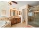 Bathroom featuring a tub, shower, vanity with granite counters, and wood cabinets at 2249 E Taxidea Way, Phoenix, AZ 85048