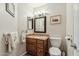 Well-lit half bathroom with a granite countertop, wooden cabinets, and neutral wall color at 2249 E Taxidea Way, Phoenix, AZ 85048