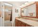 Bathroom vanity with granite counters, wood cabinets, and large mirror at 2249 E Taxidea Way, Phoenix, AZ 85048