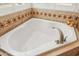 Close up of soaking tub with decorative tile detail and window at 2249 E Taxidea Way, Phoenix, AZ 85048