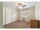 Simple bedroom with neutral walls, a ceiling fan, closet, and a window dressed with blinds at 2249 E Taxidea Way, Phoenix, AZ 85048