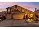 Charming two-story home featuring a three-car garage and desert landscaping at dusk at 2249 E Taxidea Way, Phoenix, AZ 85048