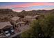 Desert homes with private driveways, garages, and neutral color scheme blend seamlessly into the rugged mountain landscape at 2249 E Taxidea Way, Phoenix, AZ 85048