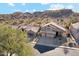 Aerial view of home with a large driveway and desert landscaping, set against a scenic mountain backdrop at 2249 E Taxidea Way, Phoenix, AZ 85048