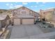 Two-story home showcasing a three car garage and manicured front yard with desert accents at 2249 E Taxidea Way, Phoenix, AZ 85048