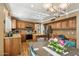 A well-appointed kitchen with wooden cabinetry, stainless steel appliances, a center island, and a dining area at 2249 E Taxidea Way, Phoenix, AZ 85048