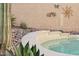 Close-up of a backyard pool featuring decorative rock landscaping and charming wall art at 2249 E Taxidea Way, Phoenix, AZ 85048