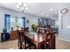 Bright dining room with a large wooden table and six chairs, adjacent to the kitchen at 26407 N 166Th Ave, Surprise, AZ 85387