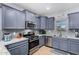 Modern kitchen with gray cabinets, granite countertops, and stainless steel appliances at 26407 N 166Th Ave, Surprise, AZ 85387
