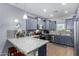 Modern kitchen with gray cabinets, granite countertops, and stainless steel appliances at 26407 N 166Th Ave, Surprise, AZ 85387