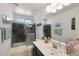 This bathroom features a walk-in shower with black tile and a sink with a large mirror at 3446 N Mayfair St, Mesa, AZ 85213