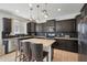Well-equipped kitchen features dark cabinets, stainless steel appliances, tile backsplash, and a central island with bar seating at 3446 N Mayfair St, Mesa, AZ 85213