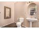 Clean bathroom with pedestal sink, toilet and large mirror at 35834 W Cartegna Ln, Maricopa, AZ 85138