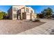 Two-story house with beige exterior, two-car garage, and desert landscaping at 35834 W Cartegna Ln, Maricopa, AZ 85138