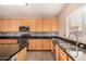 Kitchen features granite countertops, wooden cabinets and stainless steel appliances at 35834 W Cartegna Ln, Maricopa, AZ 85138