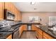 Bright kitchen boasts granite countertops, ample cabinetry, and tile flooring at 35834 W Cartegna Ln, Maricopa, AZ 85138