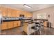 Kitchen with wood cabinets, granite counters, and stainless steel appliances at 35834 W Cartegna Ln, Maricopa, AZ 85138