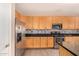 Modern kitchen with stainless steel appliances and wood cabinetry at 35834 W Cartegna Ln, Maricopa, AZ 85138