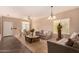 Bright living room with tiled floors, sofa, and coffee table at 35834 W Cartegna Ln, Maricopa, AZ 85138