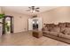 Spacious living room with tile floors, ceiling fan, and access to other rooms at 35834 W Cartegna Ln, Maricopa, AZ 85138