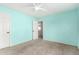 Well-lit carpeted bedroom with a ceiling fan, closet, and calming light blue walls at 415 W Midland Ln, Gilbert, AZ 85233