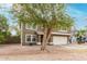 Home's front exterior showcases a mature tree, low-maintenance landscaping, and a two-car garage at 415 W Midland Ln, Gilbert, AZ 85233