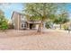 Home with xeriscaping front yard featuring a mature shade tree and two-car garage at 415 W Midland Ln, Gilbert, AZ 85233