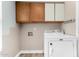 Functional laundry room with overhead cabinets and a washing machine at 415 W Midland Ln, Gilbert, AZ 85233