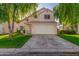 Two-story light pink house with a white garage door and well-maintained lawn at 441 S Maple -- # 13, Mesa, AZ 85206