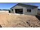 Gray single-story home showcasing unfinished backyard and covered patio ready for landscaping at 5510 W Paseo Way, Laveen, AZ 85339