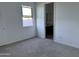 Light-filled bedroom with a window and carpet flooring. Includes attached bathroom at 5510 W Paseo Way, Laveen, AZ 85339