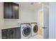 Contemporary laundry room showcases gray cabinets, quartz countertops, a herringbone accent wall, and a front load washer and dryer at 8525 E Via De Los Libros --, Scottsdale, AZ 85258