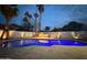 Inviting backyard pool illuminated with vibrant lighting, surrounded by palm trees and a privacy wall at 8525 E Via De Los Libros --, Scottsdale, AZ 85258