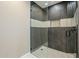 Modern shower features a glass door, gray textured tile with a niche and a white accent stripe at 8525 E Via De Los Libros --, Scottsdale, AZ 85258