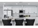 Modern kitchen with white cabinets, stainless steel appliances, and a spacious quartz-topped island at 1521 E Del Rio Dr, Tempe, AZ 85282