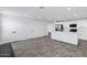 Open concept living space with a white kitchen, pantry, and gray wood-look flooring at 1521 E Del Rio Dr, Tempe, AZ 85282