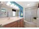 Double vanity bathroom with teal walls and shower at 19402 N Willow Creek Cir, Sun City, AZ 85373