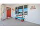 Front entry with orange door, welcome sign, and unique bench at 19402 N Willow Creek Cir, Sun City, AZ 85373