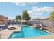 Inviting backyard oasis featuring a sparkling pool and waterfall feature at 22194 N Kingston Dr, Maricopa, AZ 85138