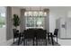 Modern dining room with glass table, black chairs, and stylish chandelier at 25076 N 150Th Ln, Surprise, AZ 85387