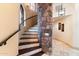 Curved staircase with stone accent wall and wrought iron railing at 28626 N 108Th N Way, Scottsdale, AZ 85262