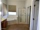 Modern bathroom featuring a soaking tub, glass shower enclosure, and wood vanity with ample countertop space at 4943 S Las Mananitas Trl, Gold Canyon, AZ 85118