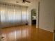 Spacious main bedroom with wood floors, sheer curtains, and doorway to en-suite bathroom at 4943 S Las Mananitas Trl, Gold Canyon, AZ 85118