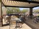 Enjoy outdoor seating area with tables, chairs, and shade structure for comfortable gatherings at 4943 S Las Mananitas Trl, Gold Canyon, AZ 85118