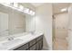 Bathroom featuring dual sinks, granite counters, and a spacious shower stall with great lighting at 5998 N 78Th St # 116, Scottsdale, AZ 85250