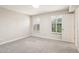 Bright bedroom with neutral carpet, bright windows with blinds, and a white door at 5998 N 78Th St # 116, Scottsdale, AZ 85250