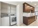 Convenient laundry area with modern washer and dryer, built-in shelving, and adjacent kitchen space with granite counters at 5998 N 78Th St # 116, Scottsdale, AZ 85250