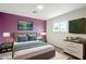 Stylish bedroom featuring a purple accent wall, nightstands, dresser, and wall-mounted TV at 7519 N 23Rd Ave, Phoenix, AZ 85021